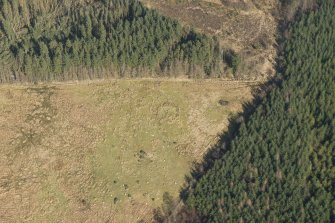 Oblique aerial view of the site of enclosure, pillboxes and trenches, looking NNE.