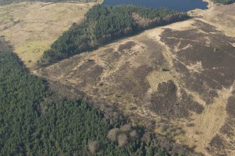 Oblique aerial view of the site of enclosure, pillboxes and trenches, looking W.