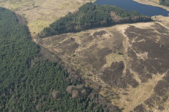 Oblique aerial view of the site of enclosure, pillboxes and trenches, looking WSW.