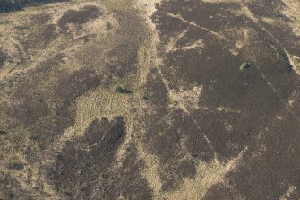 Oblique aerial view of the site of enclosure, pillboxes and trenches, looking SW.