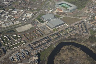 Oblique aerial view of of the Glasgow Commonwealth Games site including the athlete's village, Sir Chris Hoy Velodrome and Parkead football stadium, looking to the WNW.