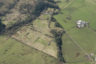 Oblique aerial view of part of the Dechmont Rifle Ranges and Gilbertfield Castle, looking SSW.