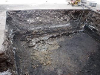 S facing section of trench, detailing cobbles at base of wall (014)