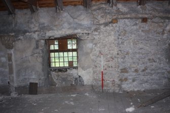 Internal upper floor, Room 4, detail of the 4th window from N on the E wall showing the stone blocking plaster surround