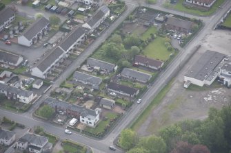 Oblique aerial view of five long rectangular single story timber  houses, looking SSE.