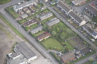 Oblique aerial view of five long rectangular single story timber houses, looking NE.