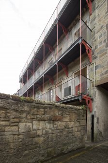 View of rear elevation of tenement block in Dunbar's Close, 137 Canongate, Edinburgh, from NW, showing 'platties' and ironwork columns.