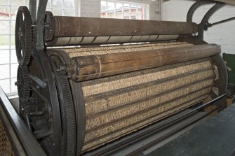 Interior. Main mill building, teazling machine, also known as a 'teazling gig'. When woollen cloth is woven and taken in from the tenter frames, it is rough in appearance. Teazling (using the seed pods of the dipsacus fullonum) raises the cloth pile and is, along with shearing and raising, a finishing process