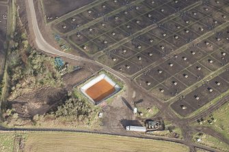 Oblique aerial view of the site of Birnie settlement at Dykeside farm under the modern pig farm, looking NE.