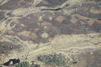 Oblique aerial view of hut circles at Big Burn near Balvonie of Leys, looking SE.