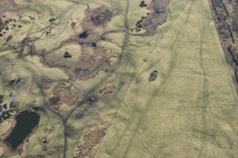 Oblique aerial view of hut circles, small cairns, field system and rig and furrow at Achvraid and Carn Glas cairns, looking S.