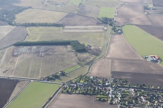 General oblique aerial view of the Cash Mill earthwork with Dunshelt village in the foreground, looking WSW.