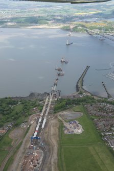 Oblique aerial view of the construction of the new Queensferry Crossing on the south bank of the Forth, looking N.