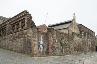 View of remnants of former boundary wall and buildings relating to former Gas Works, Old Tolbooth Wynd, Edinburgh, from NE.