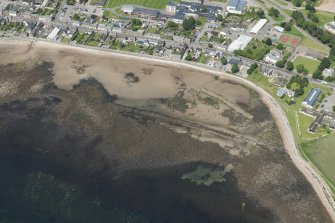 Oblique aerial view of Golspie centred on the breakwaters, looking NW.