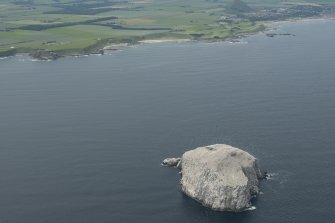 General oblique aerial view of the  Bass Rock with the East Lothian coastline beyond, looking SW.