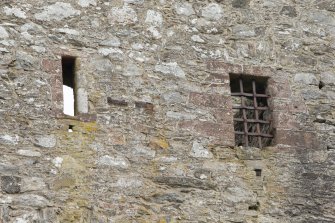 Invermark Castle. Detail of slit window and larger window with yett at 3rd floor level of west face
