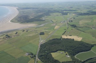 General oblique aerial view of the newly constructed A75 road line with Castle of Park in the foreground and the Piltanton Burn and Luce Sands in the distance, looking WSW.