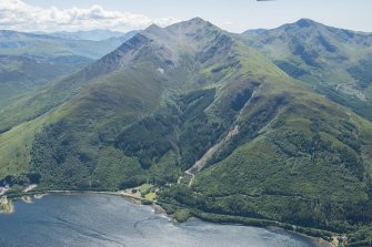 General oblique aerial view of Ballachulish centred on the Episcopal Church of St John, looking SW.