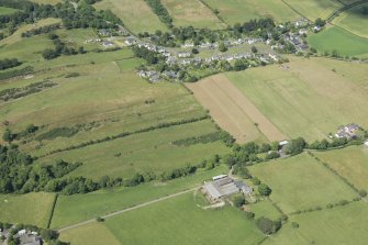 Oblique aerial view of Midlem village and the surrounding field pattern, looking N.