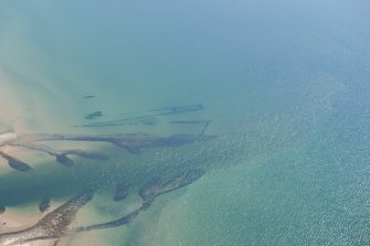 Oblique aerial view of the remains of the fish trap, looking SSE.