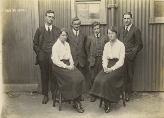 Uncaptioned photograph of a group of six people standing outside of a drawing office.