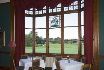 Ground floor. Dining room. View looking through bay window to course.