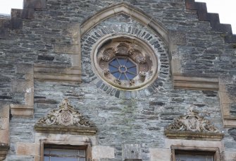 Detail of rose window and carved pediments to east gable of north elevation