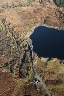 Oblique aerial view of Loch Doon dam and military remains, looking NNE.