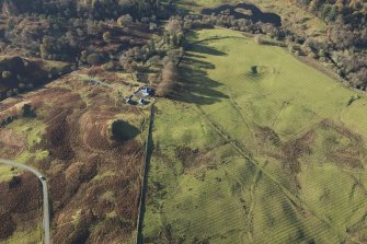 Oblique aerial view of the southern terminal of the Loch Doon Gunnery School railway,  cutting across the field and ending at a small loading platform by the Gaw Glen Burn, looking WSW.