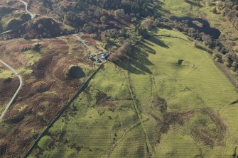 Oblique aerial view of the southern terminal of the Loch Doon Gunnery School railway,  cutting across the field and ending at a small loading platform by the Gaw Glen Burn, looking SW.