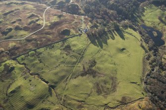 Oblique aerial view of the southern terminal of the Loch Doon Gunnery School railway,  cutting across the field and ending at a small loading platform by the Gaw Glen Burn, looking SSW.