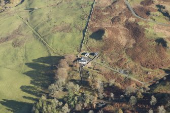 Oblique aerial view of the southern terminal of the Loch Doon Gunnery School railway,  cutting across the field and ending at a small loading platform by the Gaw Glen Burn, looking ENE.