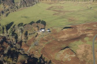 Oblique aerial view of the southern terminal of the Loch Doon Gunnery School railway,  cutting across the field and ending at a small loading platform by the Gaw Glen Burn, looking NNW.