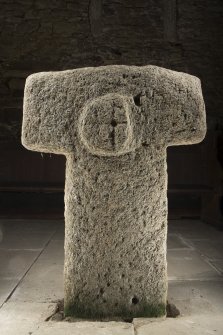 View of cruciform stone situated inside church. Peripheral lighting.