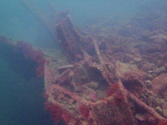 View of rock ballast, steel piping and hull plating on steamship Numidian