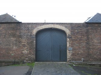 View of south boundary wall and gateway at 179 Canongate, leading into site of Gasworks, New Street, Edinburgh.