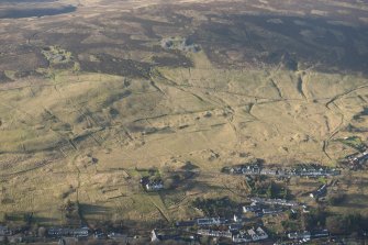 Oblique aerial view of Leadhills village, the mining remains and the field systems, looking W.