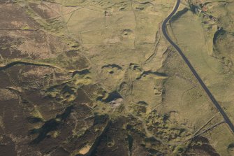 Oblique aerial view of the mining remains and field systems, looking NE.