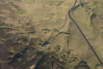 Oblique aerial view of the mining remains and field systems, looking NE.