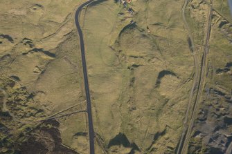 Oblique aerial view of the mining remains and field systems, looking NNE.