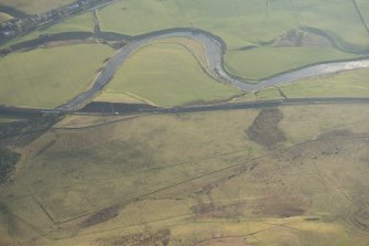 Oblique aerial view of thetrain on the West Coast Main line at Crawford and the site of the cairn, looking S.