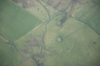 Oblique aerial view of the plantation bank, sheepfold and building with the temporary camp at the edge of frame, looking NW.