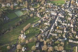 Oblique aerial view of West Linton centred on the church and the burial-ground, looking NW.