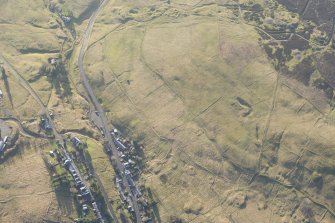 Oblique aerial view of the mining and cultivation remains and Leadhills village, looking SW.