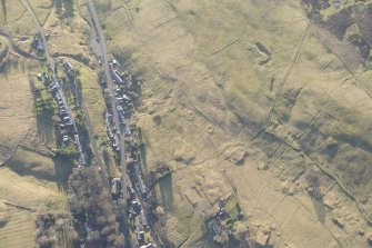 Oblique aerial view of the mining and cultivation remains and Leadhills village, looking SSW.