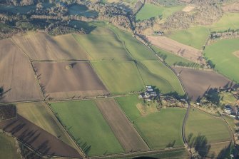 General oblique aerial view of the cairn before removal of trees and Mains of Fordie farmstead, looking NNW.