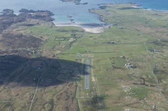 General oblique aerial view of Coll airfield with Breachacha castle and House beyond, looking SSW.