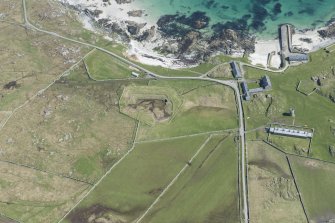 Oblique aerial view of Hynish Lighthouse shore establishment, reservoir  and harbour on Tiree, looking NE.