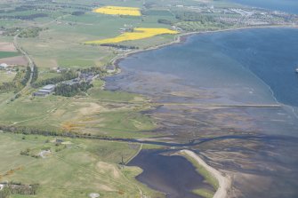 General oblique aerial view centred on the Dalmore Distillery and pier, looking NE.